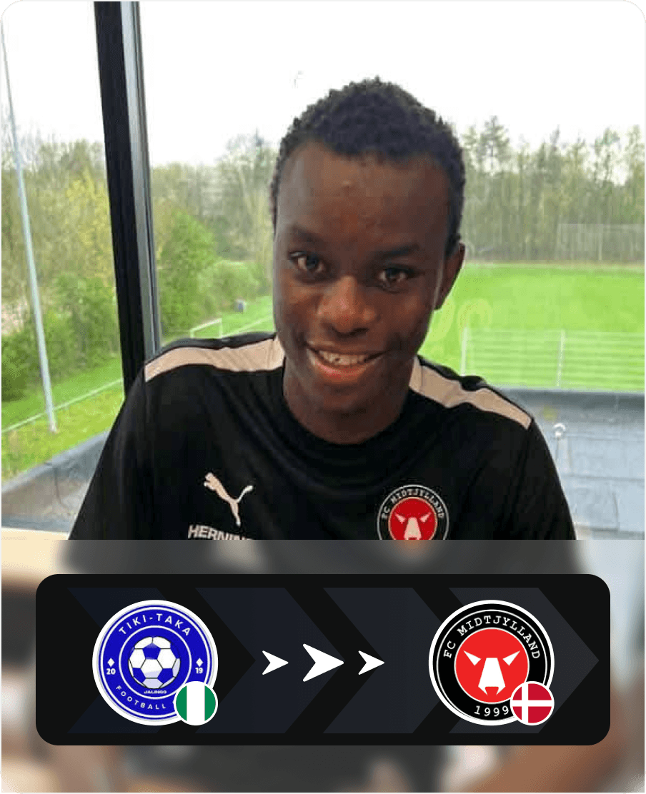 Footballer in a black t-shirt, smiling indoors, showing a transfer from a Nigerian club (blue crest) to a Danish club (red and black 'A' crest).